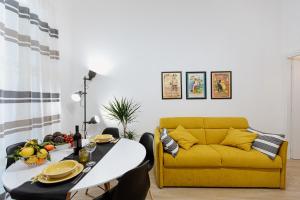 a living room with a yellow couch and a table at Les Amis in Syracuse