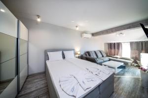 1 dormitorio con 1 cama grande y 1 sofá en Boutique Guest House"Ruvan", en Burgas