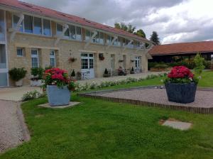 un edificio con due grandi vasi di fiori nel cortile di La Grange Champenoise ad Auménancourt-le-Grand