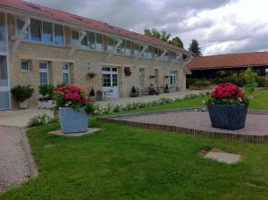 Auménancourt-le-Grand的住宿－栓潘諾伊斯旅館，院子里两盆大花的建筑