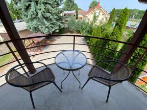 3 Stühle und ein Tisch auf dem Balkon in der Unterkunft Millennium Lux Apartments in Hajdúszoboszló