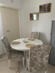 - une table et des chaises blanches dans la chambre dans l'établissement Leon Apartment, à Brăila