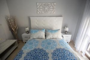 Un dormitorio con una cama azul y blanca con almohadas en MAJESTUOSA ALHAMBRA Nuevo apartamento, en Granada