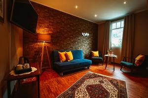 a living room with a blue couch and a brick wall at Landgasthaus am Ufer in Traben-Trarbach