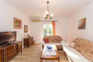 sala de estar con sofá y TV en Apartments Forte Mare, en Herceg-Novi