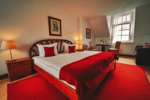 a bedroom with a large bed with a red blanket at Landgasthaus am Ufer in Traben-Trarbach