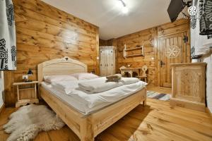 Agroturystyka "Na Borowej" في كزارني دوناجيك: غرفة نوم بسرير في غرفة بجدران خشبية