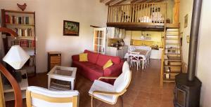 a living room with a red couch and a kitchen at GITE LA FREYDIERE in La Bégude-de-Mazenc