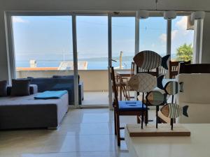 a living room with a couch and chairs and a view of the ocean at Apartments Dora in Vantačići