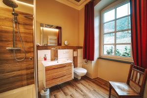 un bagno con un water, un lavandino e una finestra di Landgasthaus am Ufer a Traben-Trarbach Altre 11 foto