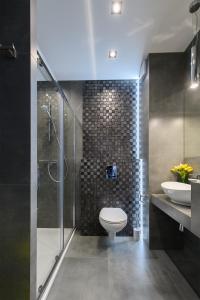 a bathroom with a toilet and a sink and a shower at Expo Home Apartment by PinPoint in Łódź