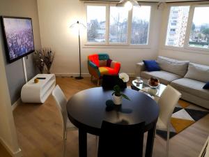 - un salon avec une table et un canapé dans l'établissement Appartement tout confort 2 chbres - 72m2 - avec terrasse et vue Pyrénées, à Pau