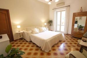 a bedroom with a white bed and a large window at L'eco delle sirene in Amalfi