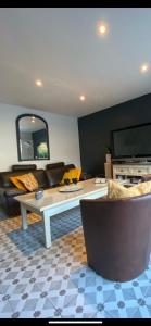 a living room with a couch and a table at Le Mahonia in Yport