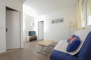 - un salon avec un canapé bleu et une table dans l'établissement Charmant 2 pièces proche de Paris, à Villeneuve-la-Garenne
