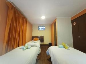 een kamer met 2 bedden en een tv. bij Isabela Hotel in La Paz