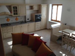a living room with a couch and a table and a kitchen at Appartamenti Meoti in Pellizzano