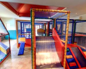 a play room with a slide and a playground at Charmant chalet te Voorthuizen in Voorthuizen +12 photos