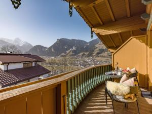 a balcony with a table and chairs and mountains at Apart Huamatl in Ramsau im Zillertal