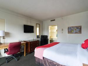 een hotelkamer met een bed, een bureau en een computer bij OYO Hotel Sumter SC Downtown in Sumter