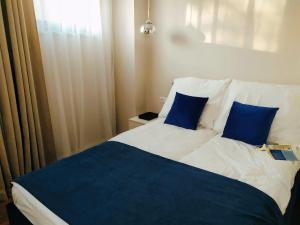 a bedroom with a bed with blue pillows at Apartamenty RÓŻANA 2 in Nałęczów