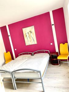 a bedroom with a bed and two yellow chairs at Schöne Ferienwohnung mit großem Garten in Flensburg