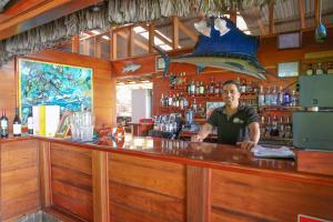 a man standing at a bar in a restaurant at Aguila de Osa Rainforest Lodge in Drake