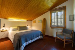 ein Schlafzimmer mit einem Bett, einem Stuhl und einem Fenster in der Unterkunft VILLA GUIMIL - GALICIA PLAYA in Villarmayor + 25 Fotos