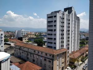 um edifício branco alto numa cidade com edifícios em Apartamento/ flat em São Vicente em São Vicente