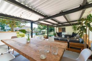 ein Esszimmer im Freien mit einem Holztisch und Stühlen in der Unterkunft VILLA GUIMIL - GALICIA PLAYA in Villarmayor