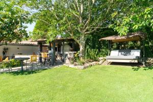 ein Garten mit einer Bank und einem Tisch und einem Baum in der Unterkunft VILLA GUIMIL - GALICIA PLAYA in Villarmayor