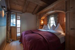Un dormitorio con una cama grande en una habitación con techos de madera. en Chalet Berghof Sertig, en Clavadel