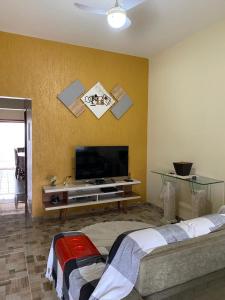 ein Wohnzimmer mit einem Flachbild-TV an der Wand in der Unterkunft Casa 8 condomínio Angra mambucaba in Angra dos Reis