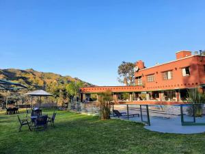 un edificio con mesas y sillas en el césped en Nuevas Cabañas Del Sol en San Lorenzo