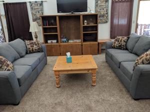 a living room with two couches and a coffee table at Lone Pine Cabins in Grand Lake