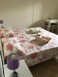 1 Schlafzimmer mit einem Bett mit rosa geblümter Bettdecke in der Unterkunft Il Ginepro in Valledoria