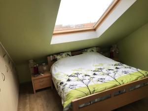 a small bedroom with a bed with a window at Duplex Blankenberge in Blankenberge