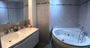 y baño con bañera, lavamanos y bañera. en Duplex Blankenberge en Blankenberge