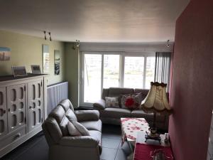 a living room with a couch and chairs and a table at Duplex Blankenberge in Blankenberge