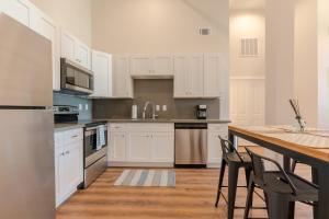 a kitchen with white cabinets and a wooden table at Meilleur in Galveston