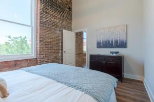 a bedroom with a bed and a brick wall at Meilleur in Galveston