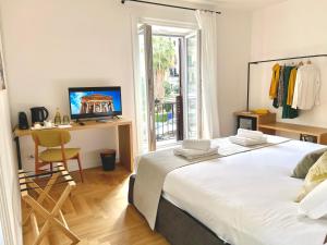 a bedroom with a bed and a desk with a computer at Archè Design Rooms and Suites in Palermo