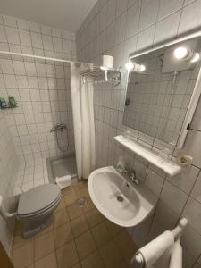 Baño blanco con aseo y lavamanos en Hard Rock Rooms for two, en Livno