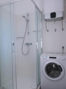 a bathroom with a shower and a washing machine at Apartments Rea in Cres