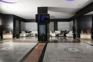 a lobby with a tv in the middle of a building at Royal Phoenicia Hotel in Manama