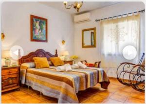 una camera da letto con un grande letto con cuscini gialli di Villa Aránzazu with private pool a Nerja