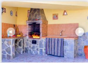 un camino in pietra in una cucina con piano cottura di Villa Aránzazu with private pool a Nerja