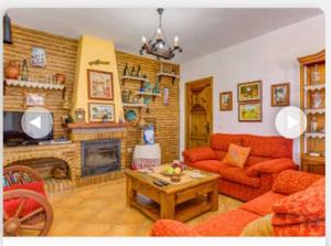 salon z czerwoną kanapą i kominkiem w obiekcie Villa Aránzazu with private pool w mieście Nerja