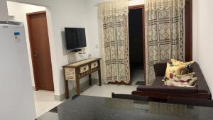 a living room with a tv and a couch and a table at Flats Solares in São Miguel dos Milagres +11 photos