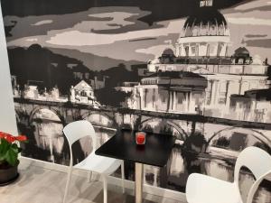 ein Esszimmer mit einem schwarzen Tisch und weißen Stühlen in der Unterkunft MARITZA S HOUSE IN ROME in Rom